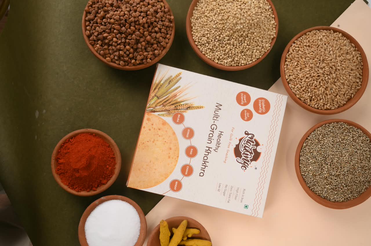 Whole grains, chana and spices around a Snackingo box